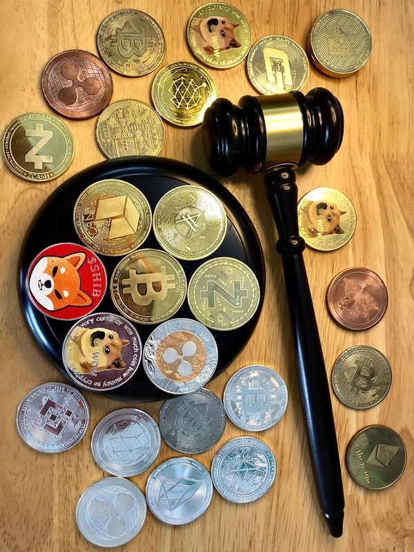 Various cryptocurrency coins arranged around a judge's gavel