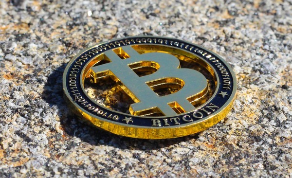 Bitcoin coin lying on a stone surface outdoors