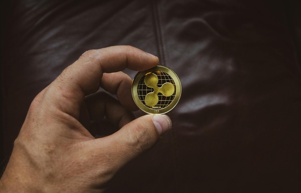 Hand holding a Ripple (XRP) cryptocurrency coin